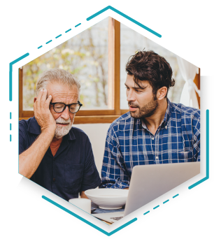 A man and his father are focused on a laptop, sharing a moment of engagement and discussion.