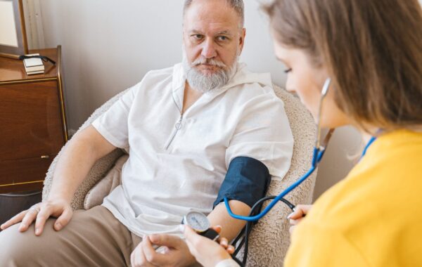 A man seated with a stethoscope draped over his arm, symbolizing respite care in a healthcare setting.