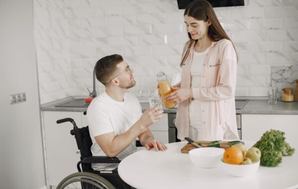 Female caregiver supporting an elderly woman at home