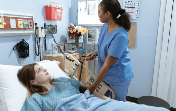 pexels-rodnae-productions-6129676 A nurse is helping a patient in a hospital bed, ensuring their comfort and addressing their medical needs.